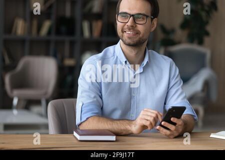 Homme souriant utilisez un smartphone pour la pensée à distance Banque D'Images