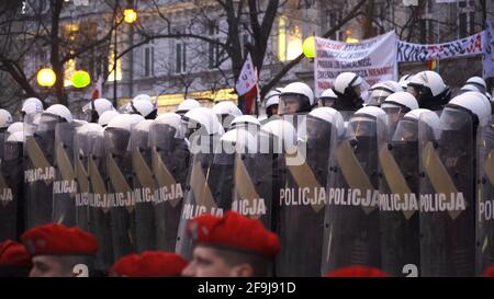 Varsovie, Pologne 11.12.2018 Marsz Niepodleglosci - des partisans nationalistes portant des casques avec des bannières. Le jour de l'indépendance nationale de la Pologne. Militaire en premier plan portant un béret rouge. Banque D'Images