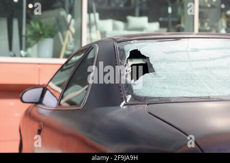 Gros plan de la lunette arrière cassée d'une voiture noire Banque D'Images