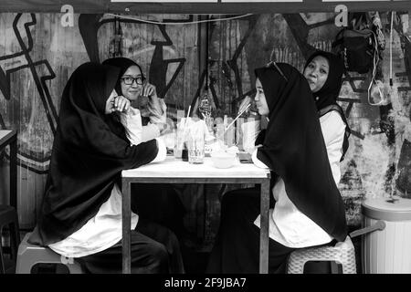Jeunes femmes indonésiennes en buvant des boissons gazeuses au café de la rue Malioboro, Yogyakarta, Indonésie. Banque D'Images