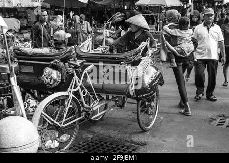 Un becak traditionnel (cycle Rickshaw) et chauffeur, rue Malioboro, Yogyakarta, Indonésie. Banque D'Images