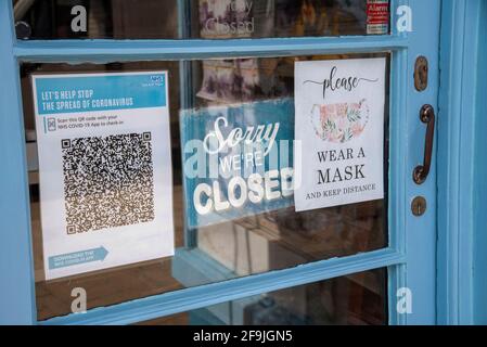 Angleterre, Royaume-Uni. 2021. Porte de magasin avec panneau fermé et code QR de Test et Trace Covid-19 pour application NHS. Portez un masque. Banque D'Images