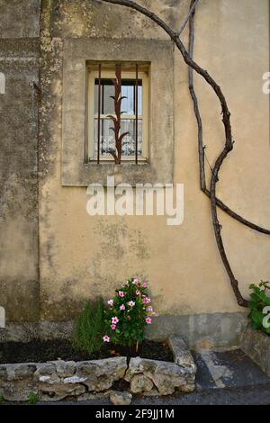Façade de maison de campagne de style provençal avec fenêtre sur un mur d'ocre abîmé dans le village pittoresque de Lourmarin dans le Vaucluse, Provence France. Banque D'Images