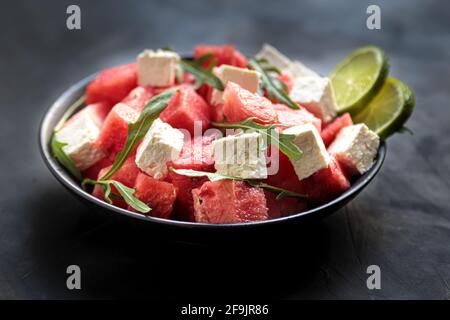 Salade de pastèque avec feta, arugula, citron vert dans un bol. Cuisine helthy naturelle, repas de légumes frais et savoureux. Cuisine méditerranéenne, dîner frais i Banque D'Images