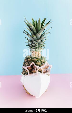 Ananas avec lunettes de soleil étoiles et masque de protection. Concept de sécurité de voyage Banque D'Images