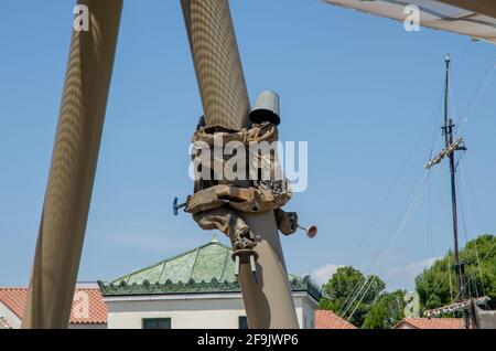 Une statue humaine avec un seau sur sa tête s'accroché à une colonne de soutien dans un parc d'attractions PortAventura. Banque D'Images