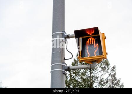 Signal d'arrêt de la main rouge piéton sur le poteau contre le ciel Banque D'Images