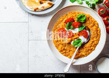 Soupe de lentilles vegan à la coriandre et aux tomates, espace de copie. Soupe Dal avec tomates. Concept de cuisine indienne. Banque D'Images