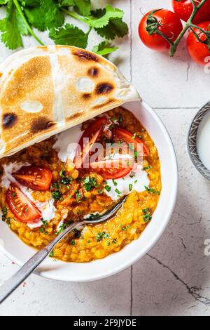 Soupe de lentilles vegan à la coriandre et aux tomates. Soupe Dal avec tomates. Concept de cuisine indienne. Banque D'Images