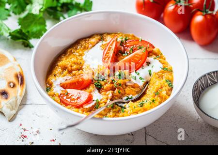 Soupe de lentilles vegan à la coriandre et aux tomates. Soupe Dal avec tomates. Concept de cuisine indienne. Banque D'Images