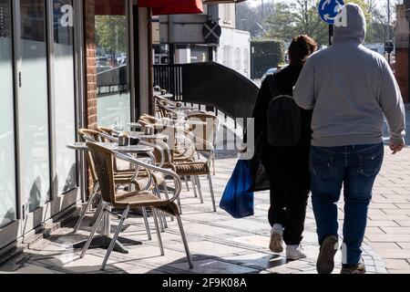 Kingston upon Thames London UK, avril 19 2021, deux personnes anonymes marchant devant un café vide salon extérieur comme Covid restrictions sont levées Banque D'Images