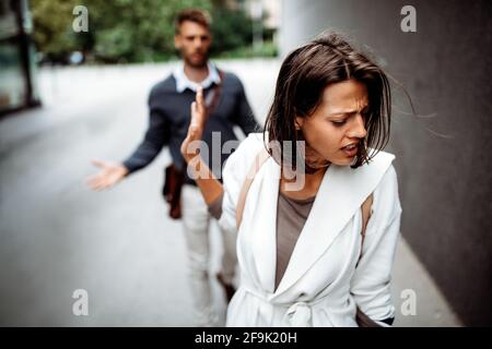 Une jeune femme triste et un homme en plein air dans la rue ayant des problèmes de relation Banque D'Images