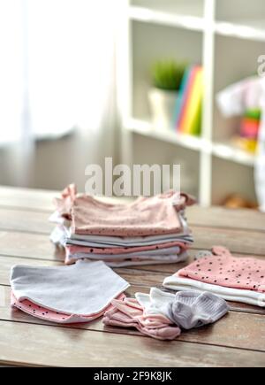 des vêtements de bébé sur une table en bois à la maison Banque D'Images