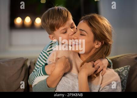 bonne mère et fils embrassant et embrassant à la maison Banque D'Images