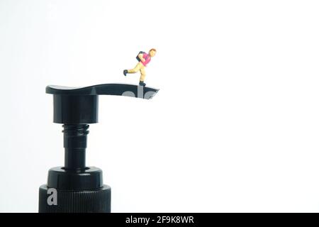 Rouvrir la classe scolaire sur la pandémie du virus corona. Les enfants ou les enfants doivent passer au-dessus du flacon désinfectant pour les mains. Photographie miniature de jouets de personnes minuscules. Banque D'Images