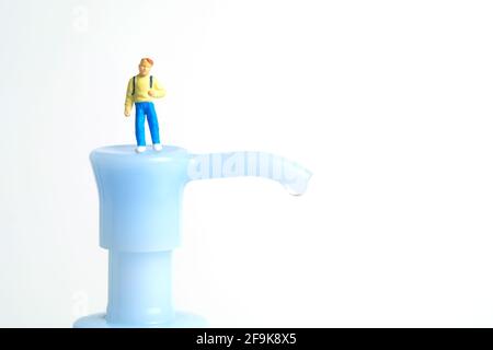 Rouvrir la classe scolaire sur la pandémie du virus corona. Les enfants ou les enfants doivent passer au-dessus du flacon désinfectant pour les mains. Photographie miniature de jouets de personnes minuscules. Banque D'Images