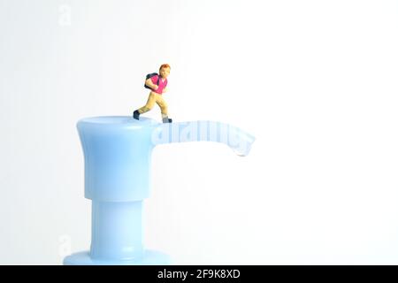 Rouvrir la classe scolaire sur la pandémie du virus corona. Les enfants ou les enfants doivent passer au-dessus du flacon désinfectant pour les mains. Photographie miniature de jouets de personnes minuscules. Banque D'Images