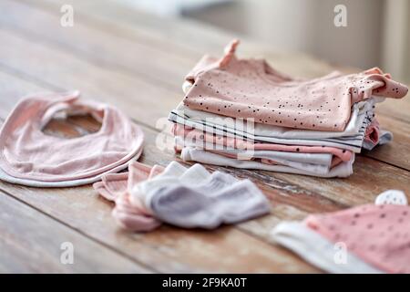 des vêtements de bébé sur une table en bois à la maison Banque D'Images