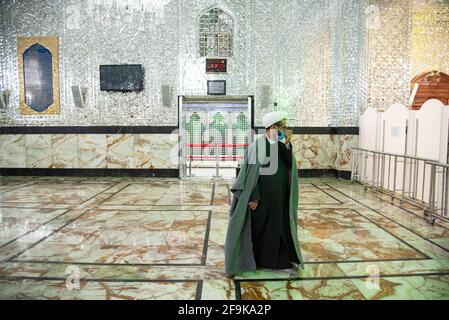 Un religieux iranien portant un masque protecteur marche près du sanctuaire de Shah Abdol-Azim.le sanctuaire de Shah Abdol-Azim est protégé par une bande rouge pour empêcher les visiteurs de le toucher et de l'épidémie de COVID-19 . (Photo de Sobhan Farajvan / Pacific Press/Sipa USA) Banque D'Images