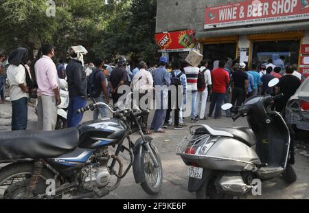 Les gens flirtent avec les normes de distanciation sociale alors qu'ils font la queue pour acheter de l'alcool dans un magasin de vin et d'alcool avant le confinement de 7 jours imposé par le gouvernement de New Delhi.le ministre en chef de Delhi Arvind Kejriwal annonce d'imposer un confinement à partir de 22h ce soir pendant 7 jours pour s'attaquer au Covid-19 en pleine ascension cas dans la capitale. Banque D'Images