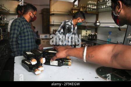 New Delhi, Inde. 19 avril 2021. Les gens flirtent avec les normes de distanciation sociale alors qu'ils font la queue pour acheter de l'alcool dans un magasin de vin et d'alcool avant le confinement de 7 jours imposé par le gouvernement de New Delhi.le ministre en chef de Delhi Arvind Kejriwal annonce d'imposer un confinement à partir de 22h ce soir pendant 7 jours pour s'attaquer au Covid-19 en pleine ascension cas dans la capitale. (Photo par Naveen Sharma/SOPA Images/Sipa USA) crédit: SIPA USA/Alay Live News Banque D'Images