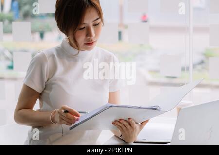 Travail d'audit, l'homme d'affaires travaille avec un document papier sur le tableau de découpe au bureau Banque D'Images