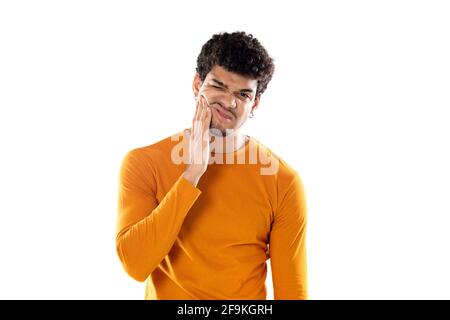 Mignon africain américain avec une coiffure afro portant une orange T-shirt isolé sur fond blanc Banque D'Images