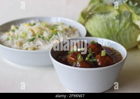 Riz basmati cuit à la vapeur avec œufs brouillés et oignons de printemps, appelé riz aux œufs servi avec du manchurien de légumes. Prise de vue sur fond blanc Banque D'Images