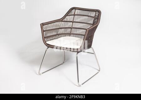 Chaise d'extérieur moderne en rotin brun avec pattes en métal isolées arrière-plan blanc Banque D'Images