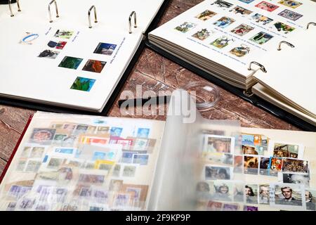 Albums de timbres-poste remplis de timbres-poste britanniques utilisés posés une table rustique en bois Banque D'Images