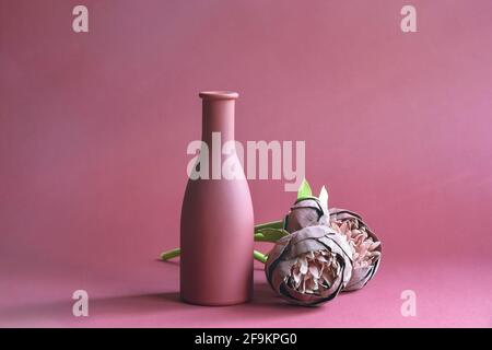 Élégant vase à fleurs roses et fleurs artificielles de pivoine faites à la main sur fond rouge. Gros plan. Copier l'espace. Mise au point sélective. Banque D'Images