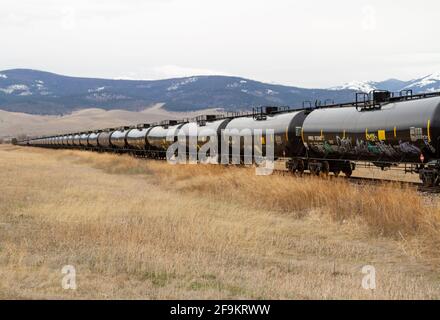 Une série de wagons-citernes inutilisés se trouve sur une longue distance de voie ferrée qui attend d'être remis en service, en Amérique du Nord. Banque D'Images