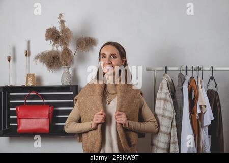 Femme millénaire à la mode avec chandail sur ses épaules debout cabines d'essayage Banque D'Images