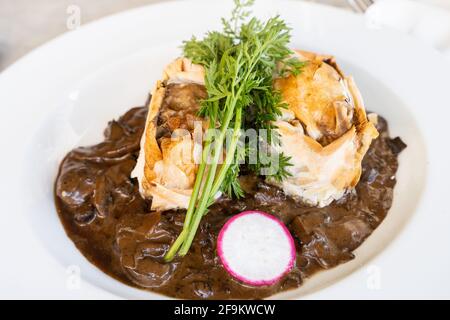 Assiette de steak de bœuf panée avec sauce aux champignons et feuilles de persil. Concept de restaurant gastronomique Banque D'Images