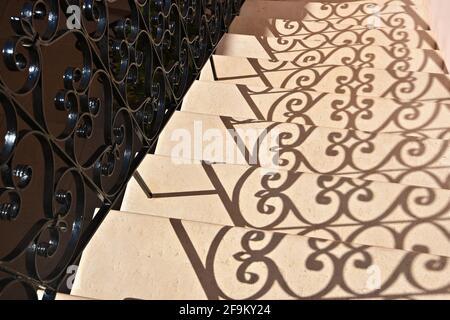 Silhouette de balustrade en fer fait à la main sur un escalier en marbre rose à Chania, île de Crète, Grèce. Banque D'Images