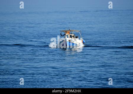 Bord de mer avec un bateau de pêche grec traditionnel sur les eaux du golfe de la Canée en Crète, Grèce. Banque D'Images