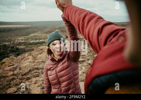 Caucasiens femelle randonnée avec mâle haut cinq après avoir atteint la montagne sourire aux sommets Banque D'Images