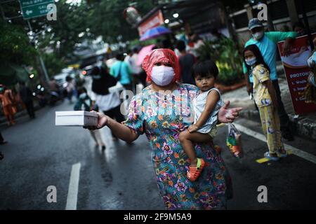 Jakarta, Indonésie. 15 avril 2021. Les résidents font la queue en appliquant la règle de distance teh pour obtenir takjil gratuit sur les routes du centre de Jakarta. Les résidents sont tenus de faire la queue en appliquant une distance de deux mètres pour prévenir la propagation du coronavirus. EEveryday le comité fournit gratuitement 400-600 paquets takjil qui sont des dons de résidents et des entreprises de la région. Crédit : Muhammad Zaenuddin/ZUMA Wire/Alay Live News Banque D'Images