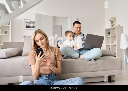 Une jeune famille avec un enfant à la maison regardant des films en ligne, surfant sur les médias sociaux. Banque D'Images