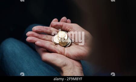 Les mains froissées d'une femme âgée comptant des pièces de monnaie. Gros plan. Photo de haute qualité Banque D'Images