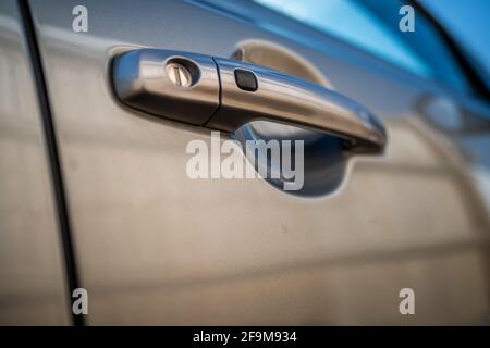 Poignée de porte avant latérale d'un véhicule automobile Suzuki gris avec profondeur de champ et bokeh intentionnels peu profonds Banque D'Images