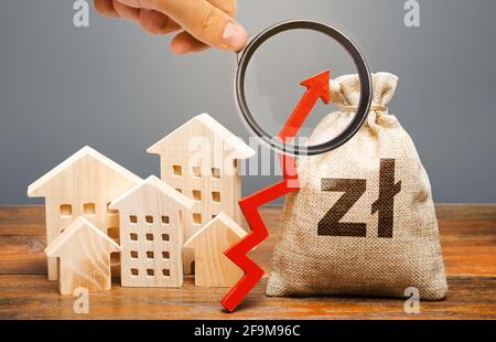 Un sac d'argent polonais et des bâtiments résidentiels avec une flèche vers le haut. Le concept de l'augmentation du coût du logement. La croissance du loyer et du taux hypothécaire Banque D'Images