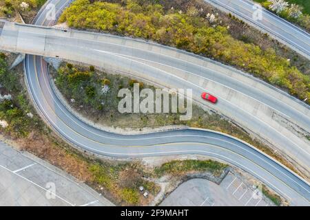 Voiture solitaire sur la bretelle d'accès courbe de l'autoroute, États-Unis Banque D'Images