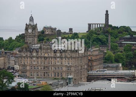 Édimbourg, Écosse - 13 juin 2019 : les monuments au sommet d'une colline sur Calton Hill, avec l'hôtel Balmoral ci-dessous, sont montrés dans une vue large pendant une journée nuageux, vu Banque D'Images