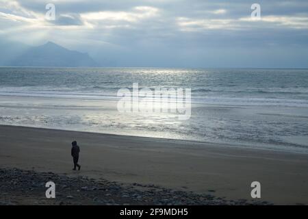 Pays de Galles, péninsule de Llyn Paysage côtier d'hiver à Dinas Denile, près de la ville royale de Caernarfon brodant des nuages spectaculaires près de crépuscule Sun Glinting sur t Banque D'Images