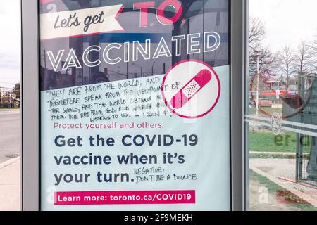 Le signe de la campagne de vaccination Covid-19 a été vandalisé par des écritures chrétiennes faisant la promotion du contraire exact. Il est vu sur une TTC (Toronto Transit Commission) Banque D'Images