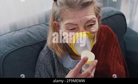 Une vieille femme malade inhalant de l'oxygène à la maison. Photo de haute qualité Banque D'Images