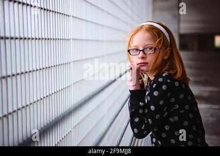 Triste solitaire entre fille avec des cheveux rouges dans le garage de stationnement. Banque D'Images