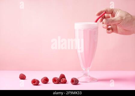 Une paille en métal écologique réutilisable, c'est-à-dire dans un milkshake de framboise Banque D'Images