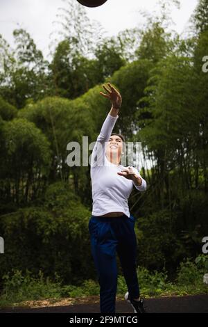 Tir vertical d'une femme hispanique avec des cheveux blonds jouant basket-ball Banque D'Images